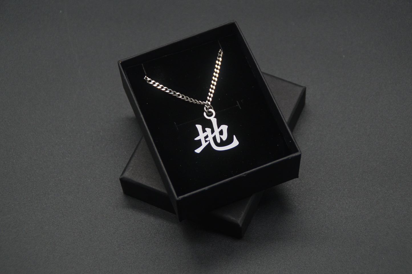 Erde Kanji Halskette aus der Godai Kollektion. Minimalistischer Japan Schmuck mit dem (地) Chi-Schriftzeichen als Edelstahl Anhänger in einer edlen Geschenkbox verpackt.