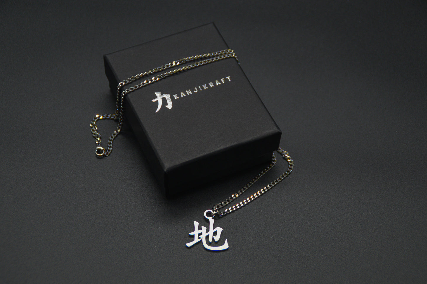 Erde Kanji Halskette aus der Godai Kollektion. Minimalistischer Japan Schmuck mit dem (地) Chi-Schriftzeichen als Edelstahl Anhänger auf einer edlen KanjiKraft Geschenkbox.