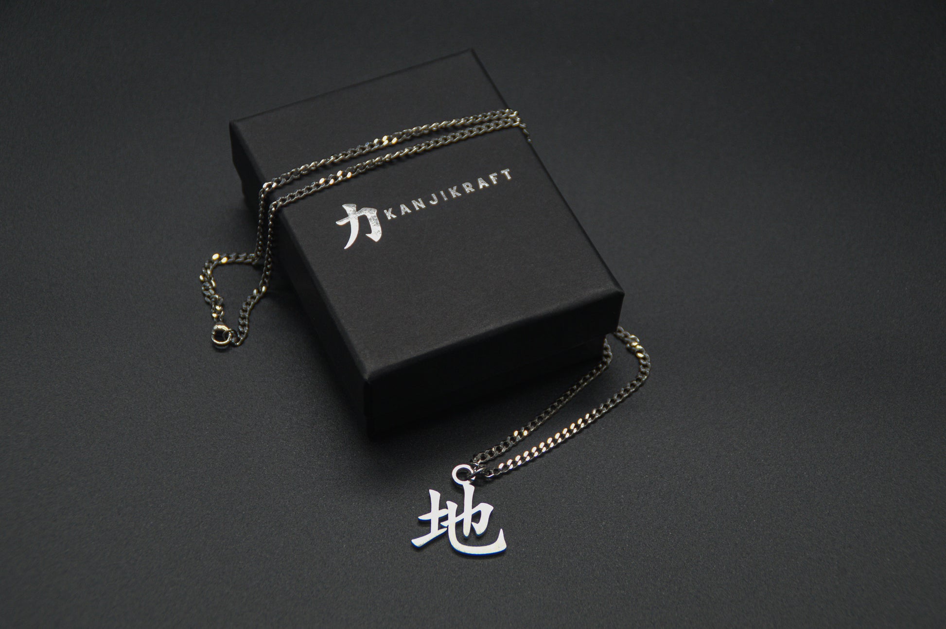 Erde Kanji Halskette aus der Godai Kollektion. Minimalistischer Japan Schmuck mit dem (地) Chi-Schriftzeichen als Edelstahl Anhänger auf einer edlen KanjiKraft Geschenkbox.