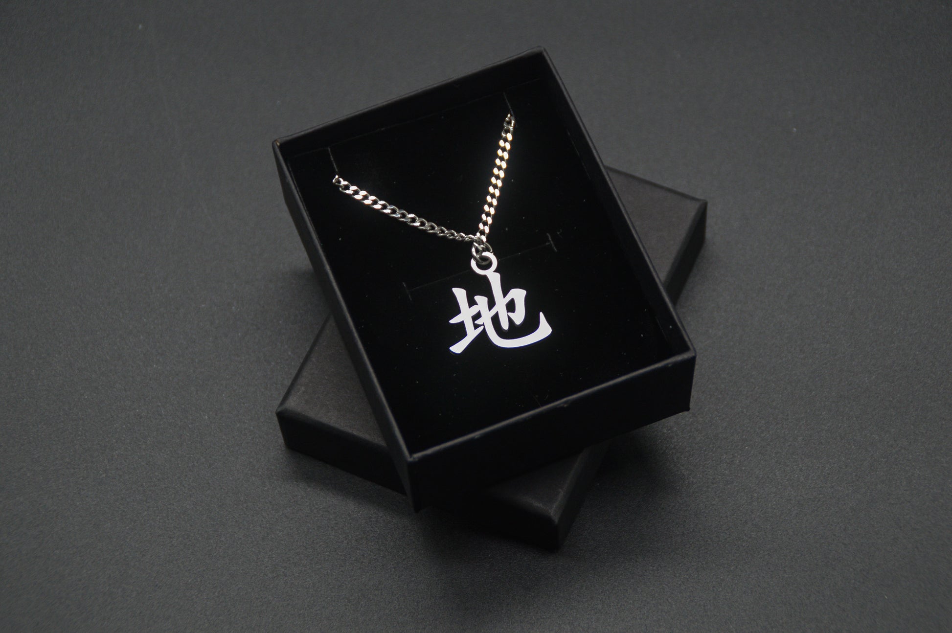 Erde Kanji Halskette aus der Godai Kollektion. Minimalistischer Japan Schmuck mit dem (地) Chi-Schriftzeichen als Edelstahl Anhänger in einer edlen Geschenkbox verpackt.