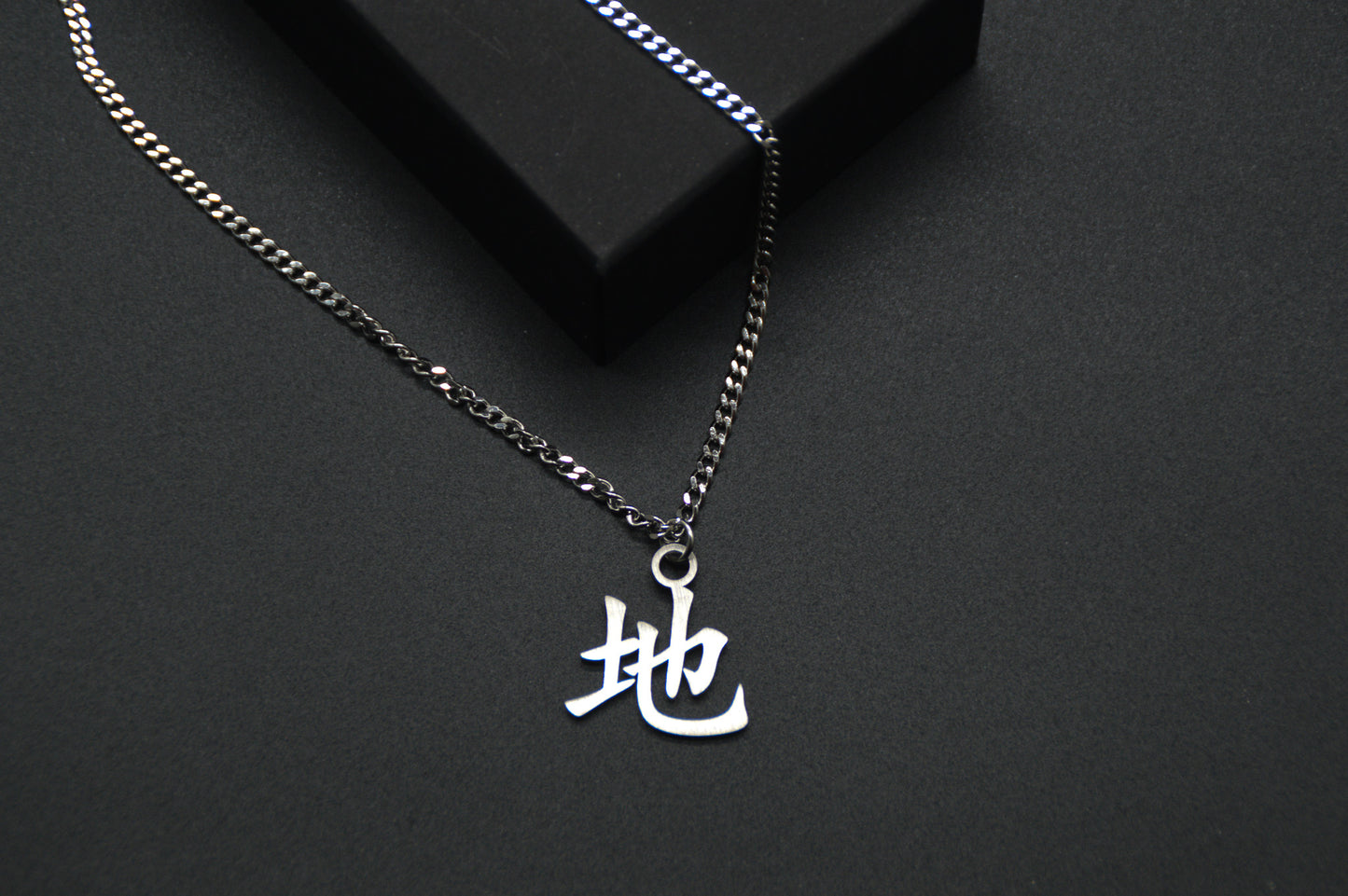 Erde Kanji Halskette aus der Godai Kollektion. Close Up Japan Schmuck mit dem (地) Chi-Schriftzeichen als Edelstahl Anhänger. 