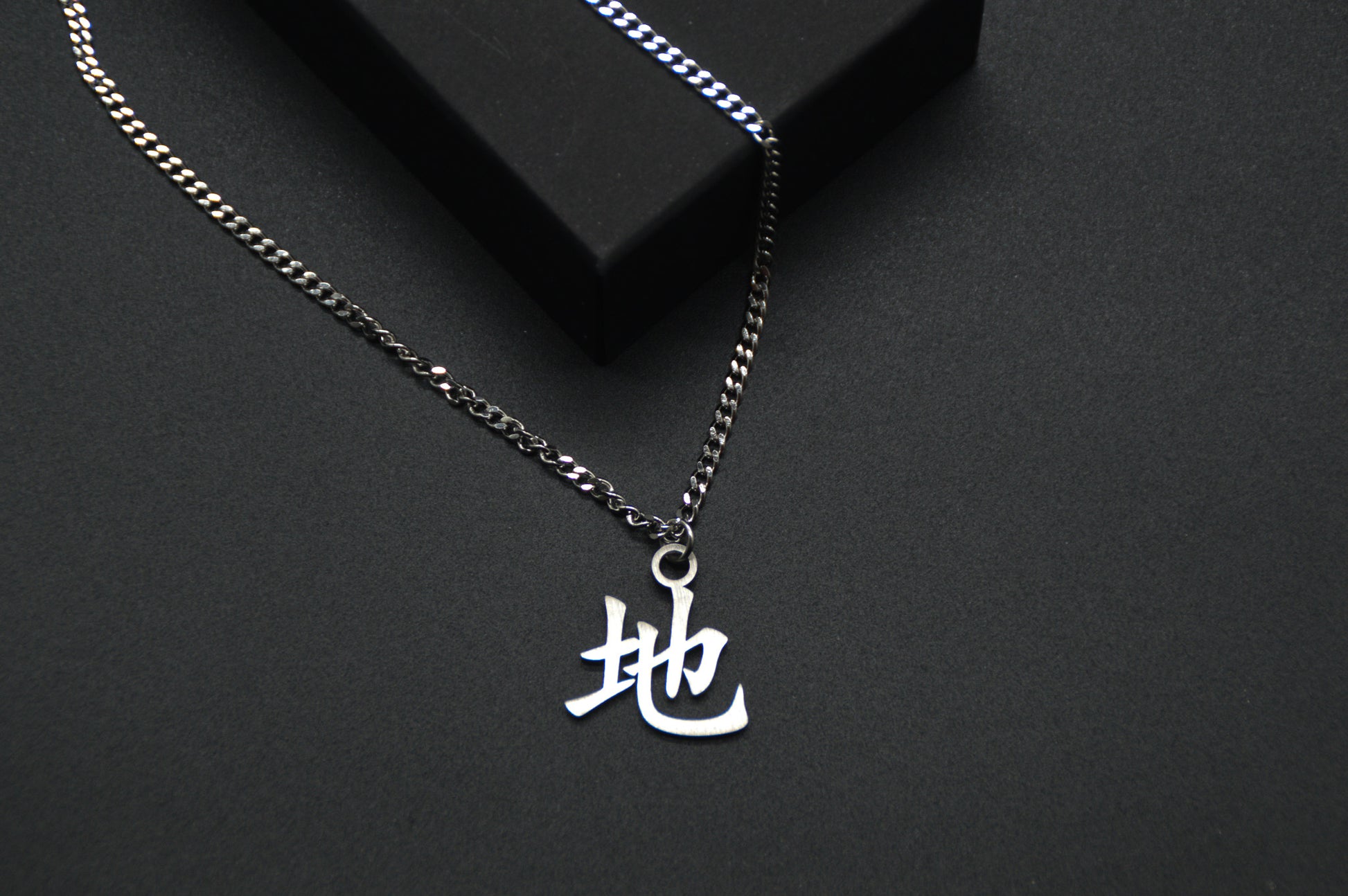 Erde Kanji Halskette aus der Godai Kollektion. Close Up Japan Schmuck mit dem (地) Chi-Schriftzeichen als Edelstahl Anhänger. 