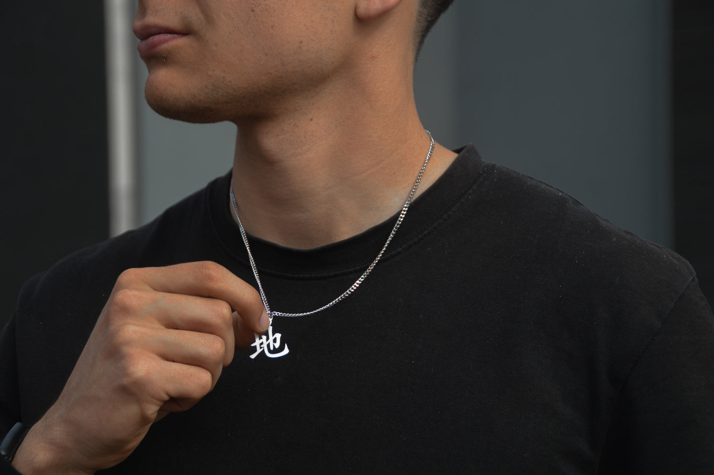 (地) Erde Kanji Halskette aus der Godai Kollektion. Getragen von unseren Model und in die Kamera gehalten. Es sitzt perfekt und sieht cool aus.