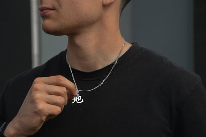 (地) Erde Kanji Halskette aus der Godai Kollektion. Getragen von unseren Model und in die Kamera gehalten. Es sitzt perfekt und sieht cool aus.