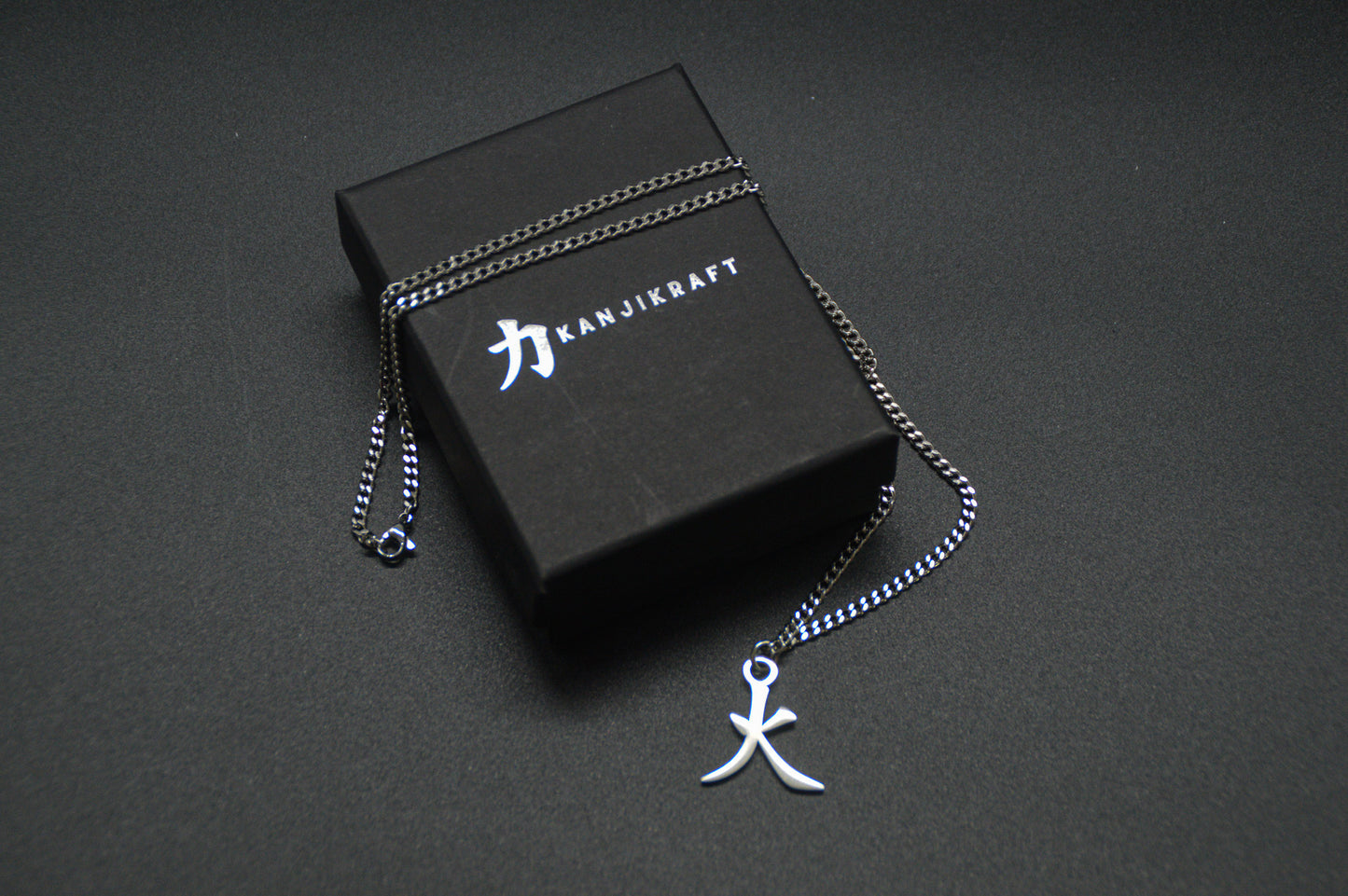 Feuer Kanji Halskette aus der Godai Kollektion. Minimalistischer Japan Schmuck mit dem (火) Hi-Schriftzeichen als Edelstahl Anhänger auf einer edlen KanjiKraft Geschenkbox.