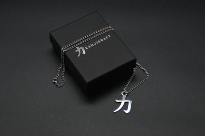Das Japanische Schriftzeichen für Kraft als Edelstahlkette auf einem Schwarzen Hintergrund auf einer edlen KanjiKraft Geschenkbox. Das gleiche Kanji wie im Logo von KanjiKraft.