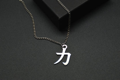 Das Japanische Schriftzeichen für Kraft als Edelstahlkette auf einem Schwarzen Hintergrund im Close Up und leicht auf einer Kante liegend. Das gleiche Kanji wie im Logo von KanjiKraft,