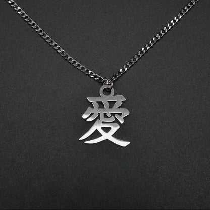 Das Japanische Schriftzeichen (Kanji für Liebe). Edelstahl Halskette mit dem Schriftzeichen 愛 als Anhänger auf einem Schwarzen Hintergrund als Nahaufnahme.