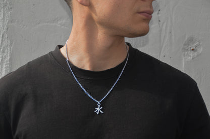 (水) Wasser Kanji Halskette aus der Godai Kollektion. Frontales Model Foto, mit schwarzem Tshirt und Blick zur Seite.