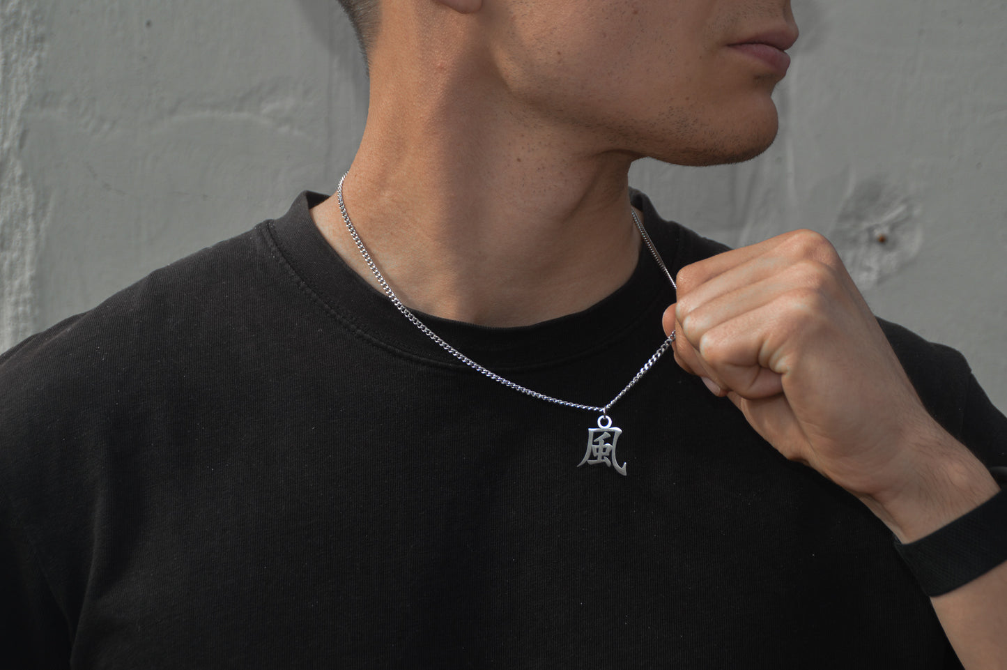 (風) Wind Kanji Halskette aus der Godai Kollektion. Getragen von unseren Model und in die Kamera gehalten. Es sitzt perfekt und sieht cool aus.